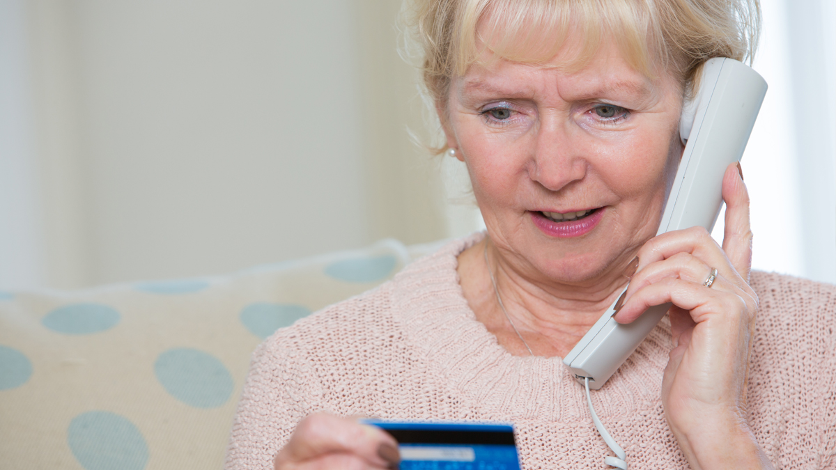 An older woman being scammed by phone.