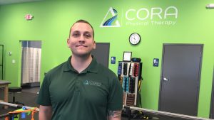Employee standing in Cora Physical Therapy Facility