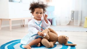 MIS-C Child holding stethoscope and stuffed animal
