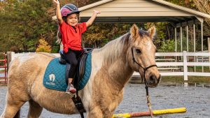 Little girl riding pony at HALTER's Therapeutic Horseback Riding program