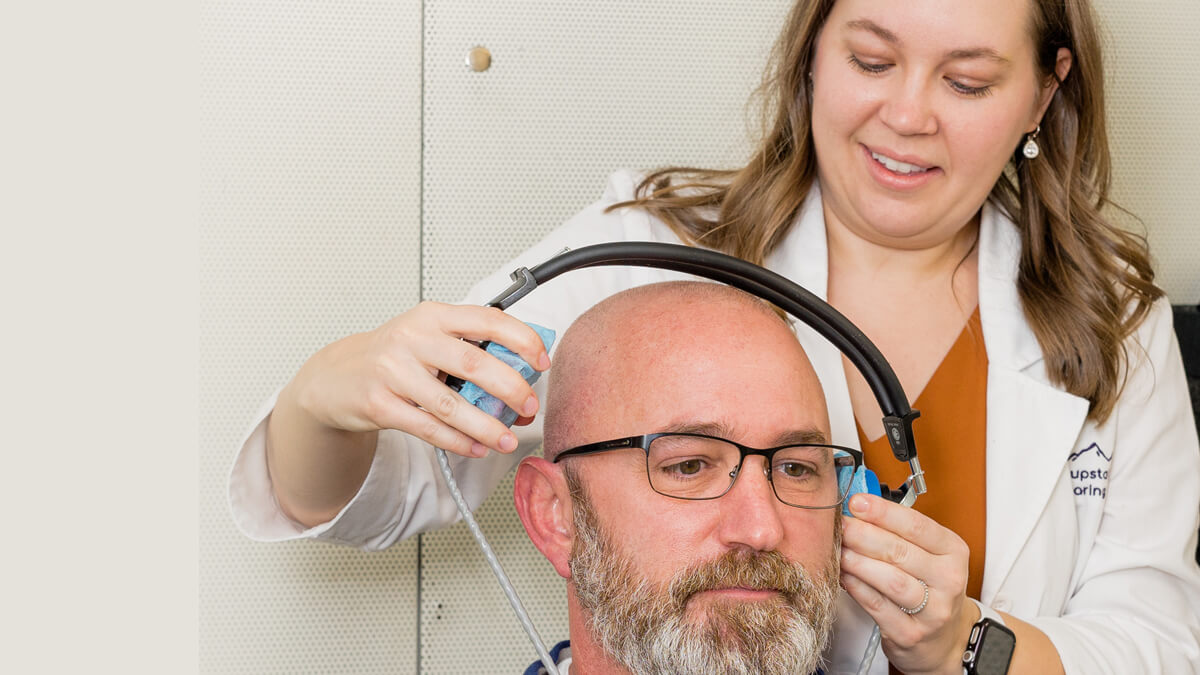 Ear doctor assisting patient with hearing exam