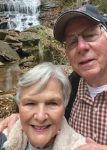Cathy McMillan and her husband in front of a waterfall