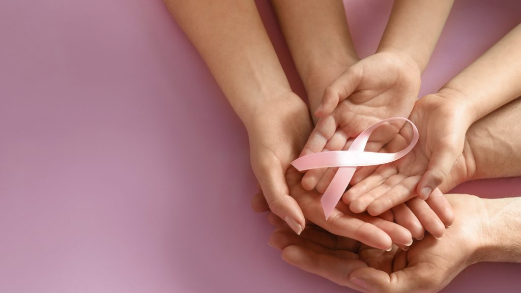 Photo of hands holding the breast cancer ribbon