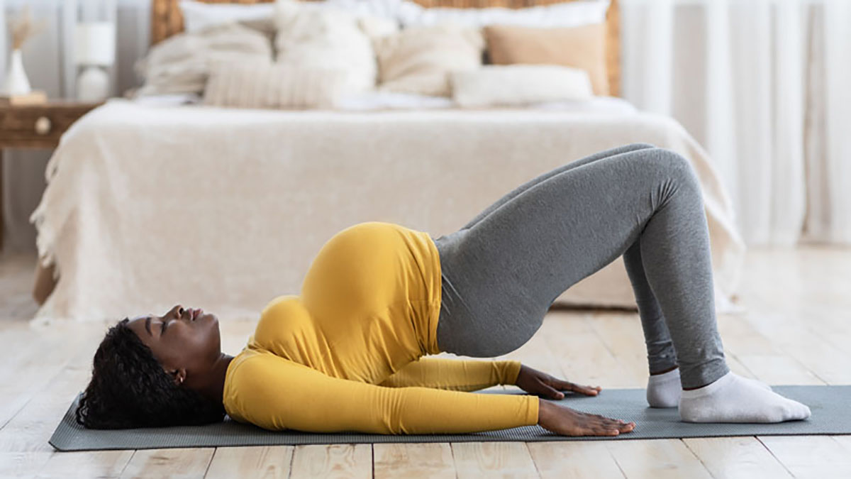 Photo of a pregnant woman who is doing an exercise on the floor