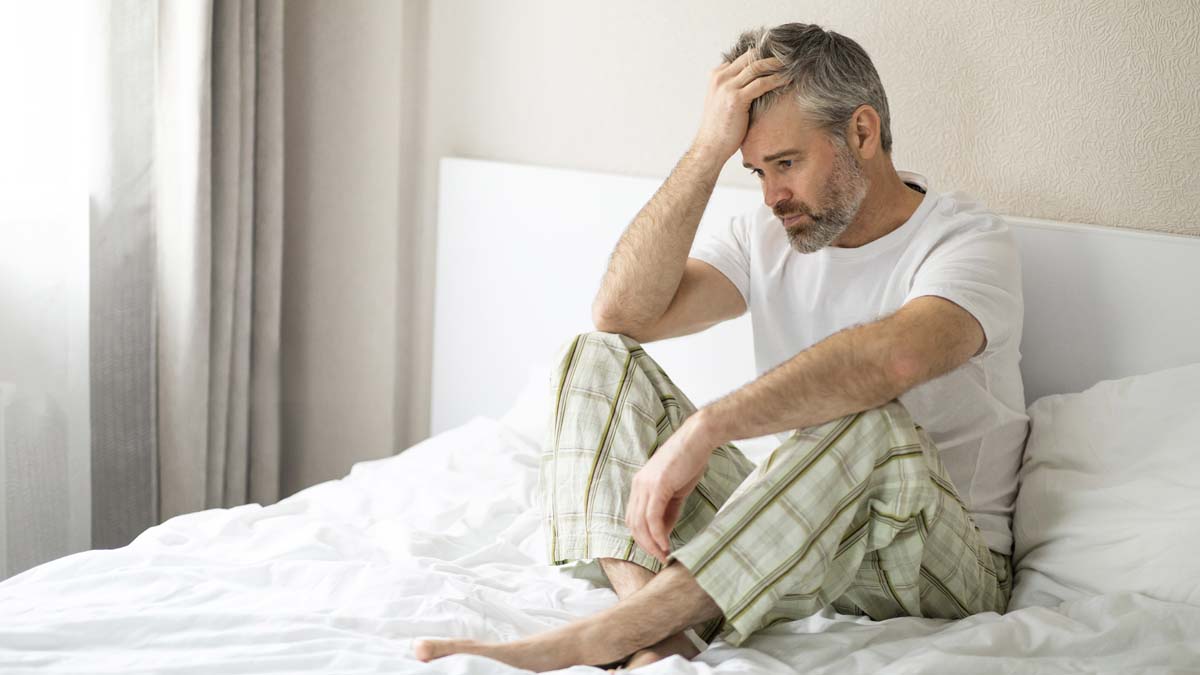 Photo of a man who is holding his head