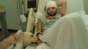Photo of man in hospital bed with a dog