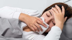 Photo of a woman laying down covering her mouth